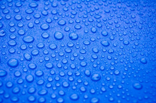 Close up of water droplets on blue cover background