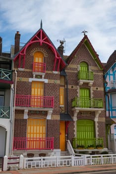 Facades of red and green painted buildings in Mers Les Bains, Normandy, France