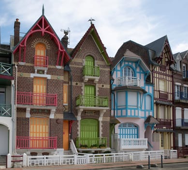 Facades of buildings in red green and blue in Mers Les Bains, Normandy, France