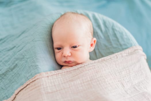 The baby is sleeping peacefully in his cozy nest. Newborn photo session captures the serene innocence and warmth of early moments.