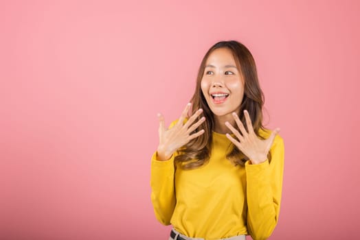 Asian happy portrait beautiful young woman teen stand surprised excited celebrating open mouth gesturing palms on face isolated, studio shot pink background with copy space, positive expression