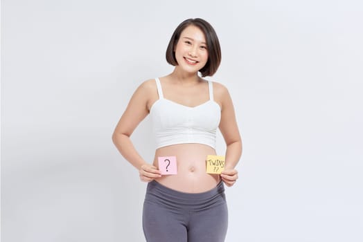 pregnant with question mark drawn on post-it sticker on belly