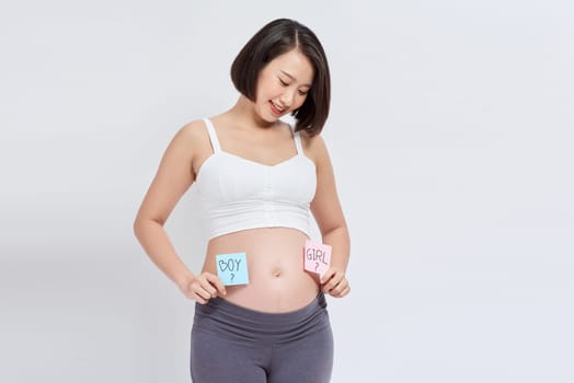 Pregnant woman with paper stickers on tummy, closeup.