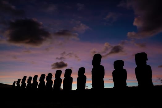 Silhouette shot of the ancient moai on Easter Island in Chile at sunset