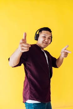 man with headphones dancing on a yellow background
