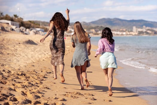 Cheerful multiethnic friends with sunglasses happy on vacation on the beach, looking at the camera.