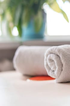 Close up shot of the white towels rolled in the massage couch.