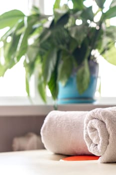 Close up shot of the white towels rolled in the massage couch.