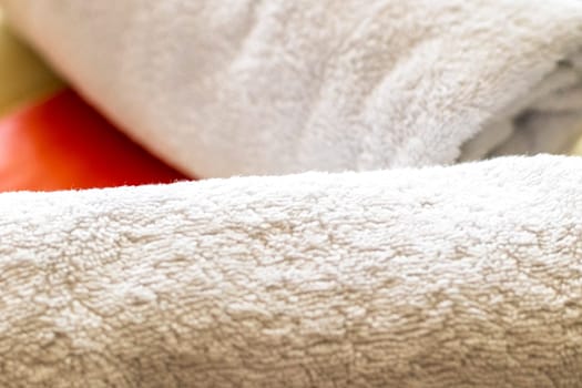 Close up shot of the white towels rolled in the massage couch.