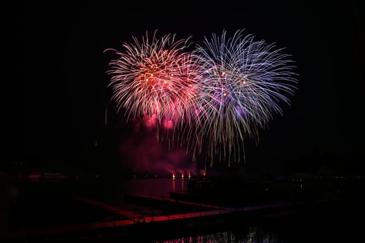 Firework. Beautiful colorful fireworks on the water surface with a clean black background. Fun festival and contest of Firefighters. Brno Dam - Czech Republic.