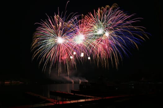 Firework. Beautiful colorful fireworks on the water surface with a clean black background. Fun festival and contest of Firefighters. Brno Dam - Czech Republic.