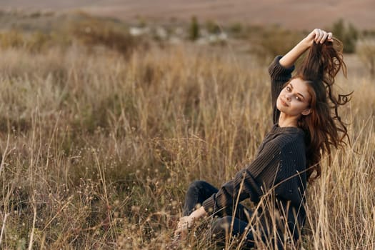 Woman enjoying the tranquility of nature as her hair sways in the wind against a majestic mountain backdrop