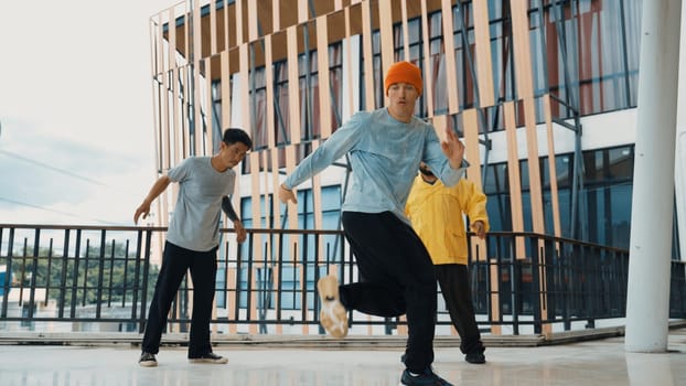 Hip hop team dance break dance while multicultural friend surrounded and clapping hands to cheer or encourage his friend to dance. Active and energetic street dance. Outdoor sport 2024. Endeavor.