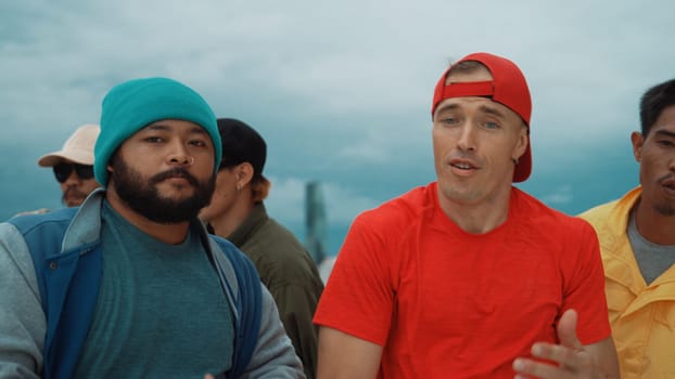 Multicultural teenagers dancing while looking at camera on rooftop with urban city view. Professional break dance group moving to hip-hop music with friends cheer. Outdoor sport 2024. Endeavor.