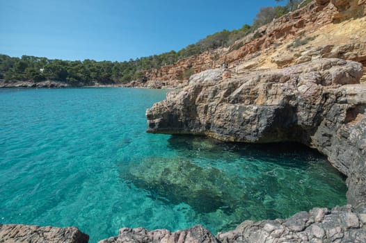 Turquoise waters of Cala Saladeta in Ibiza in summer.