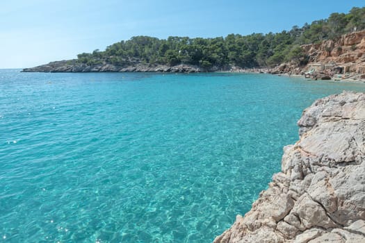 Turquoise waters of Cala Saladeta in Ibiza in summer.