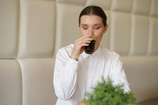 Elegant beauty caucasian woman enjoying a coffee alone in a modern cafeteria