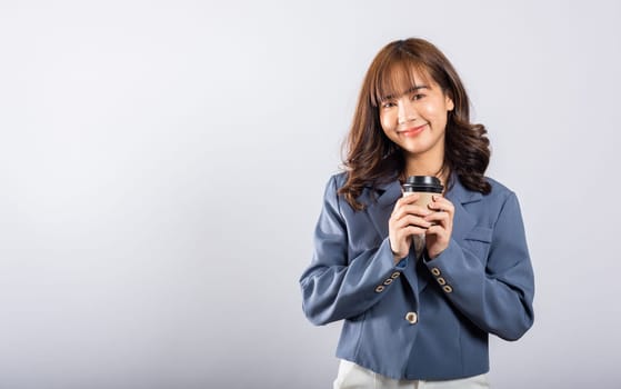 Portrait Asian beautiful happy young businesswoman standing smiling holding take away coffee paper cup, studio shot isolated on white background with copy space, coffee break