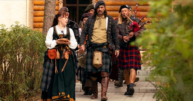 The Scottish Lord of the Clan goes with his people to the ceremony. Scottish bagpiper.