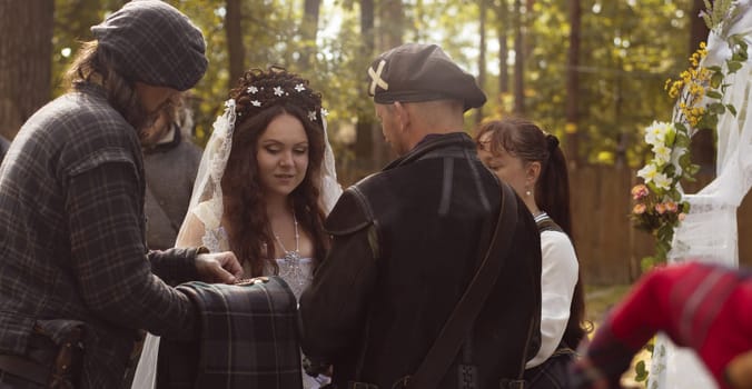 The lord of the clan presents gifts to the bride at the scottish wedding.