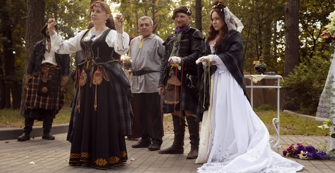 Wedding ceremony. Scottish wedding. Husband and wife are connected by the threads of fate.