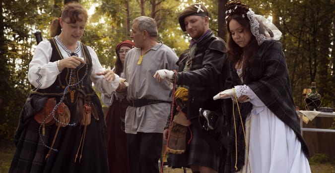 Wedding ceremony. Scottish wedding. Husband and wife are connected by the threads of fate.