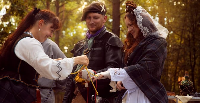 Wedding ceremony. Scottish wedding. Husband and wife are connected by the threads of fate.