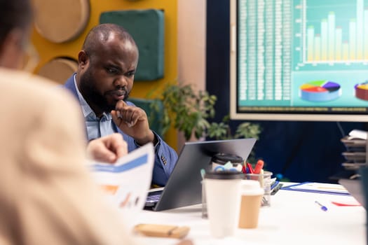 Organizational team gathering in a conference room to review sales on interactive board, increasing organizational capital and profit. PR specialists ensuring international success and productivity.