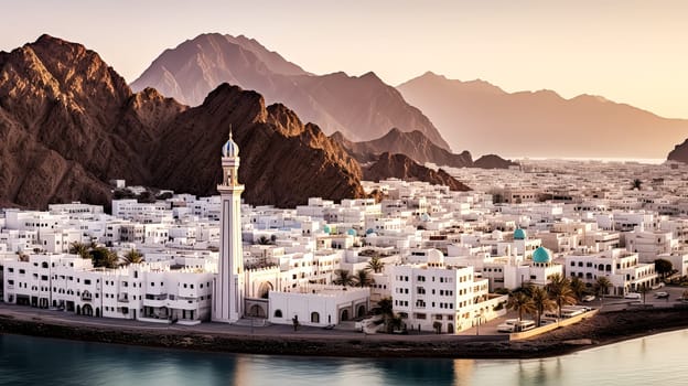 A beautiful mountain town with a large white building in the center. The town is surrounded by mountains and the ocean