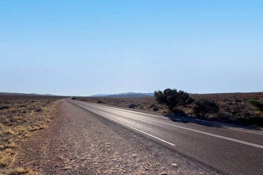 A long, deserted road stretches towards distant mountains in Ikara Flinders Ranges