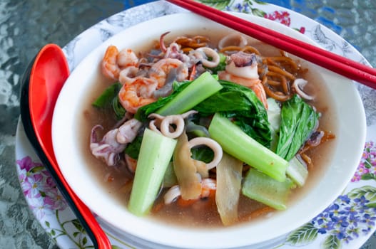 Gravy noodle served with seafood. Asian food concept.