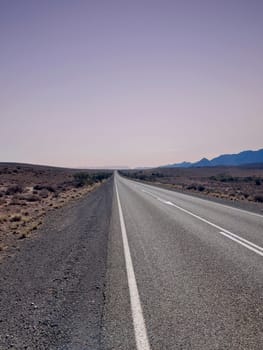 A long, deserted road stretches towards distant mountains in Ikara Flinders Ranges