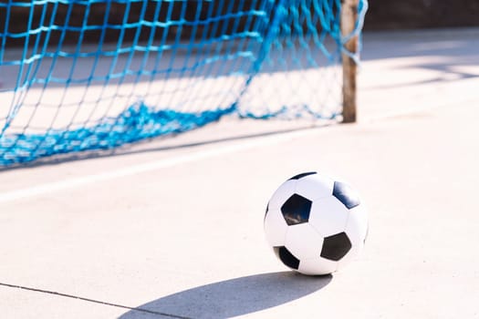 soccer ball next to the goal of an urban football court, concept of sport, copy space for text