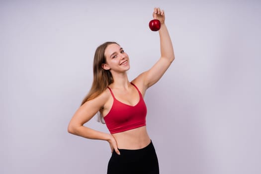 Cropped of sporty female with well fit body holding an apple, healthy food and fit body concept