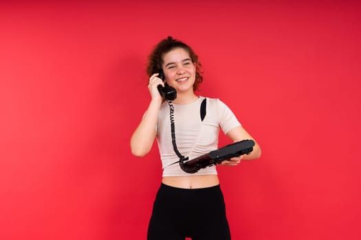 Portrait of pretty person arms hold vintage handset doubtful face isolated on a red color background