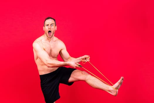 Full length portrait of a young man exercising with a skipping rope and looking at camera