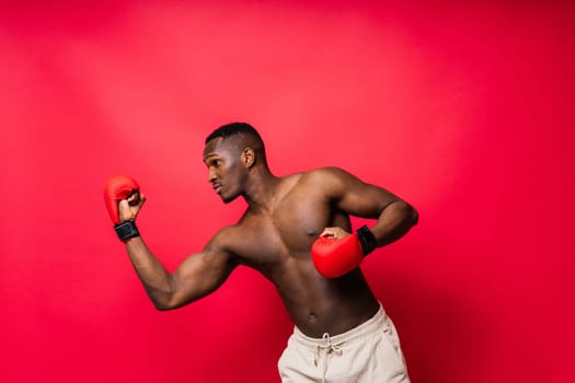 Young attractive African American male boxer with a bare torso, muscular body. Concept of training