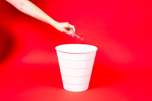 A woman throws a broken glass bowl into glass collection bin, waste sorting