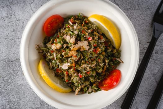 Healthy salad with capers, quinoa and walnuts on stone table