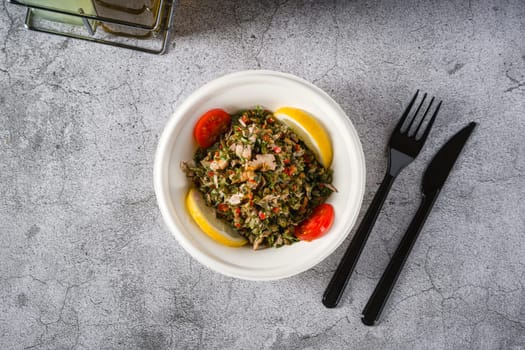 Healthy salad with capers, quinoa and walnuts on stone table