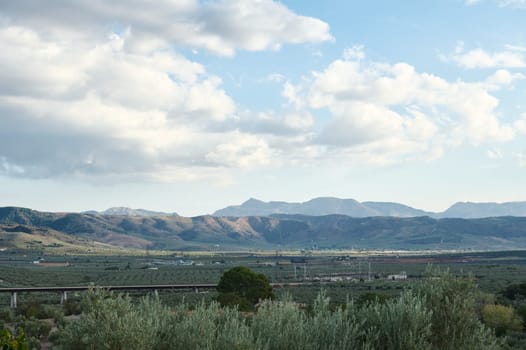 A breathtaking view of rolling mountains under a partly cloudy sky, capturing the essence of nature's beauty and tranquility.