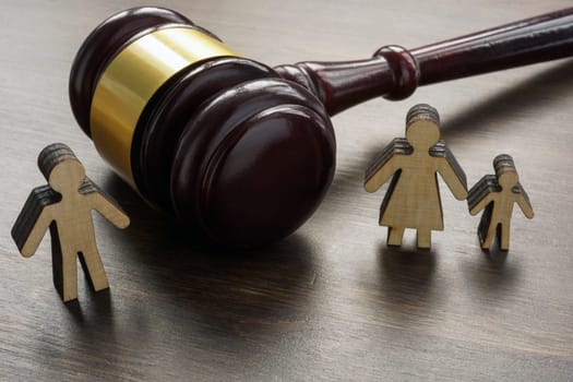 Divorce and alimony concept. Divided family figurines and gavel.