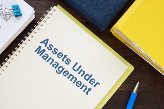 Papers about assets under management and a notebook.