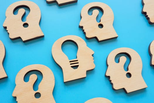Creative thinking and problem solving. Head with question marks and a light bulb.