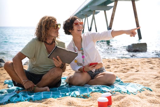 Young couple on vacation on the beach, looking for information about hotels, shopping centers and transport guides. lifestyle and travel concept.