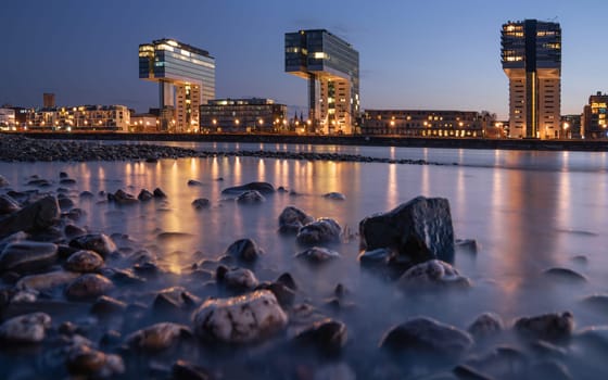 COLOGNE, GERMANY - APRIL 19, 2023: Panoramic image of modern buildings in the harbor of Cologne during nightbreak on April 19, 2023 in Germany, Europe