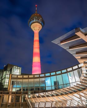 DUSSELDORF, GERMANY - MARCH 25, 2023: Illuminated Rhine Tower and state parliament of North Rhine Westphalia on March 25, 2023 in Dusseldorf, Germany, Europe