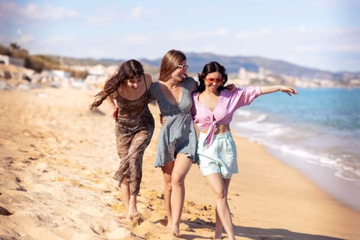 Cheerful multiethnic friends with sunglasses happy on vacation on the beach, looking at the camera.