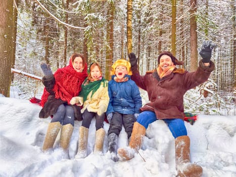 Joyful family ethnic dress with shawls and earflap hats in winter forest in carnival Maslenitsa in Russia. Tourists in Shrovetide in spring. Mother, father, son, daughter having fun in the snow