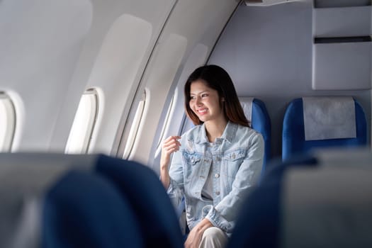 A happy tourist seated by the airplane window, enjoying the view and the travel experience. Perfect for travel, tourism, and aviation-related themes.